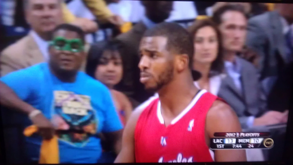 Memphis Grizzlies fan in green goggles sitting courtside